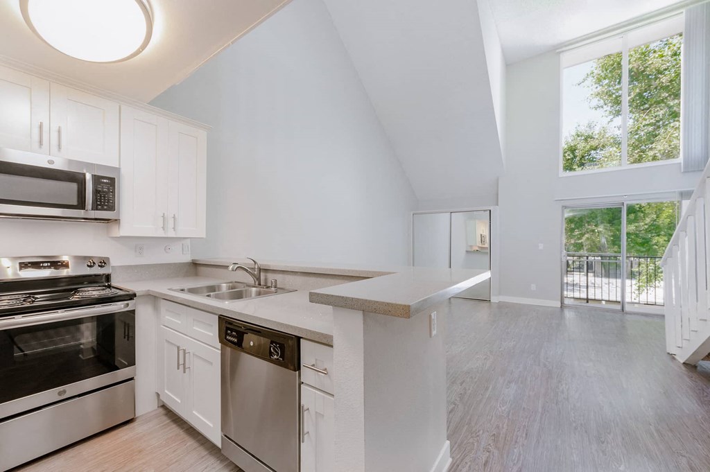 a kitchen with white cabinets and stainless steel appliances