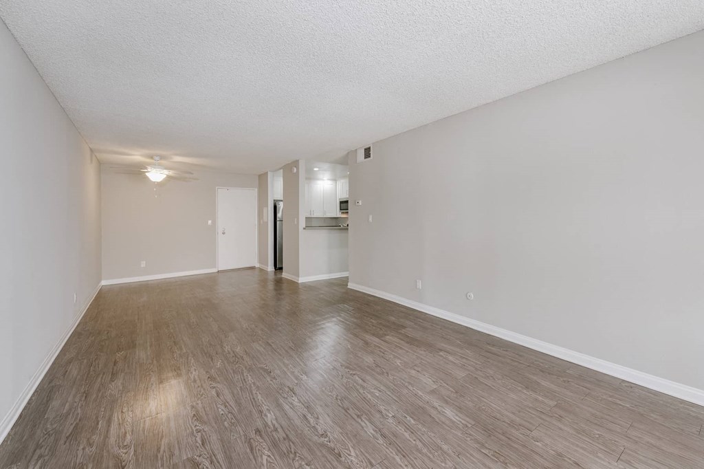 an empty living room with a hard wood floor