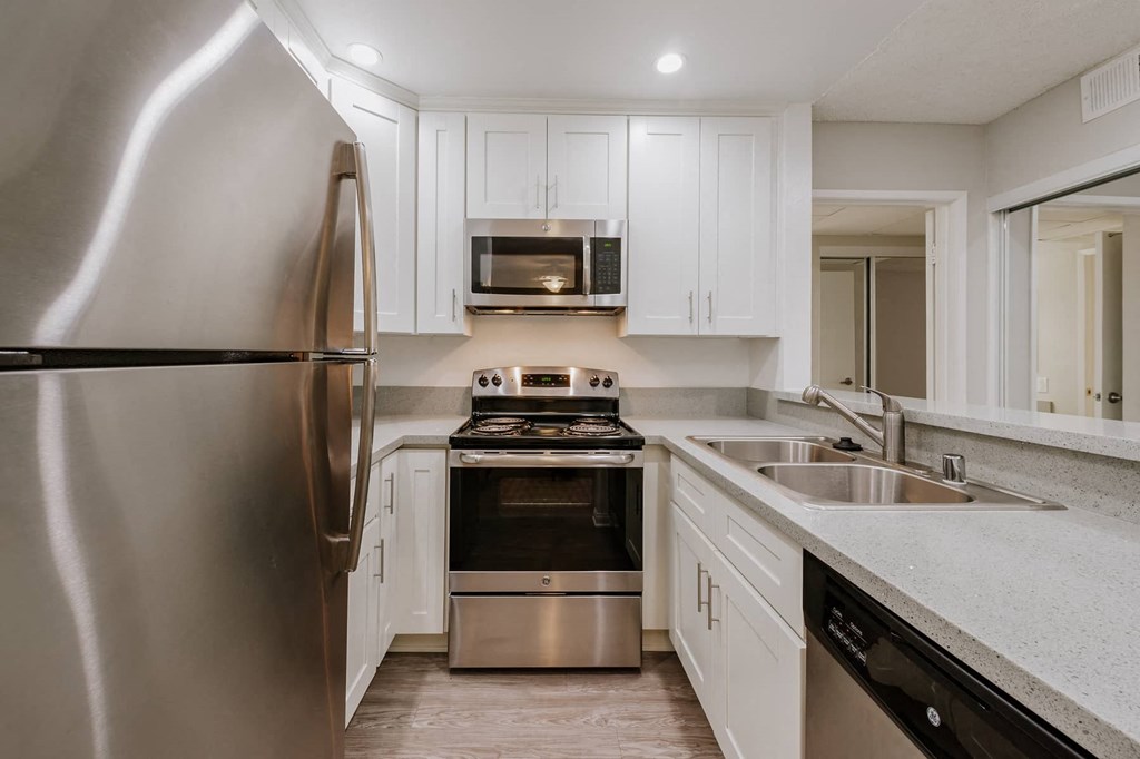 a kitchen with stainless steel appliances and white cabinets
