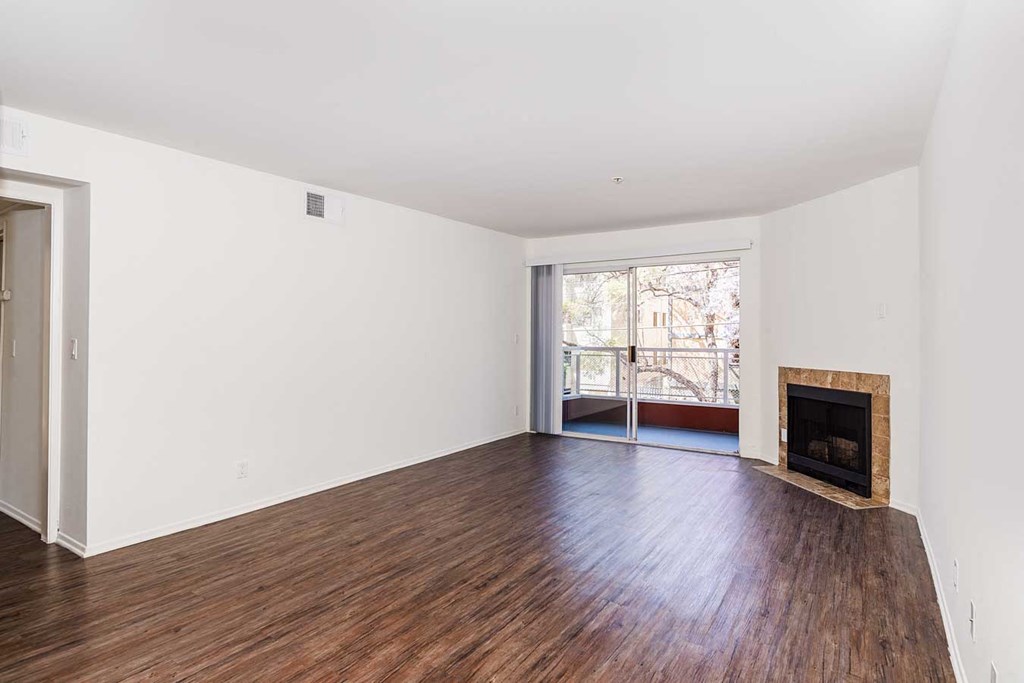a living room with a fireplace and wooden floors