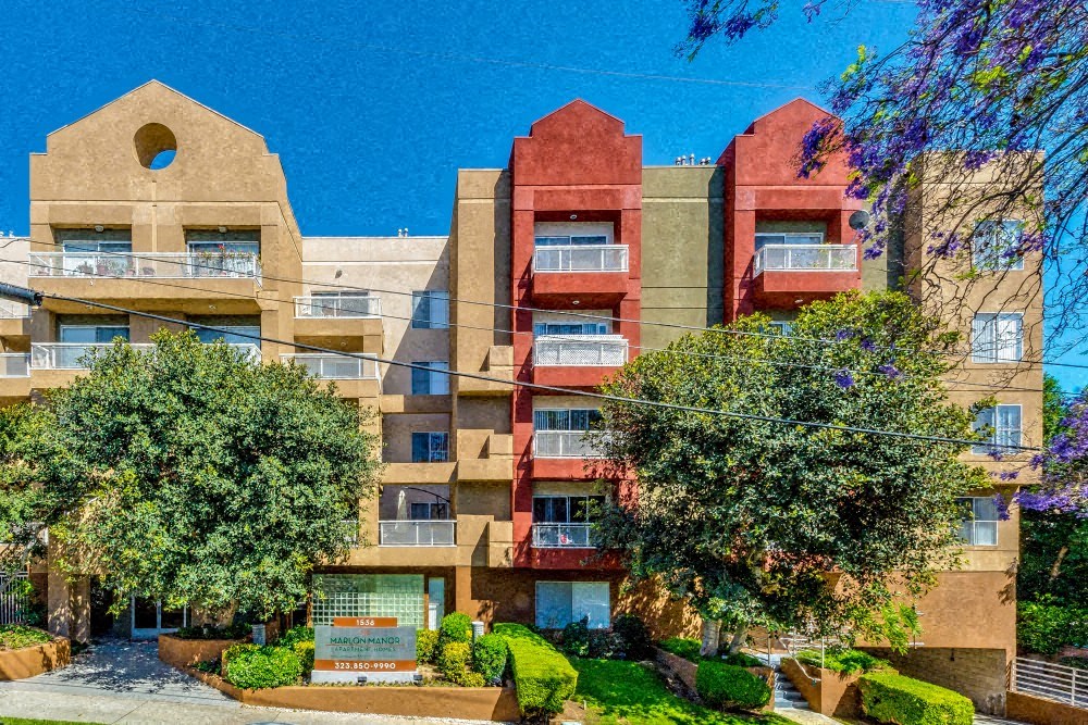 a large apartment building with trees in front of it