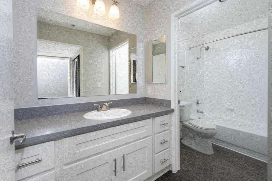 A bathroom with a sink, mirror, and toilet.