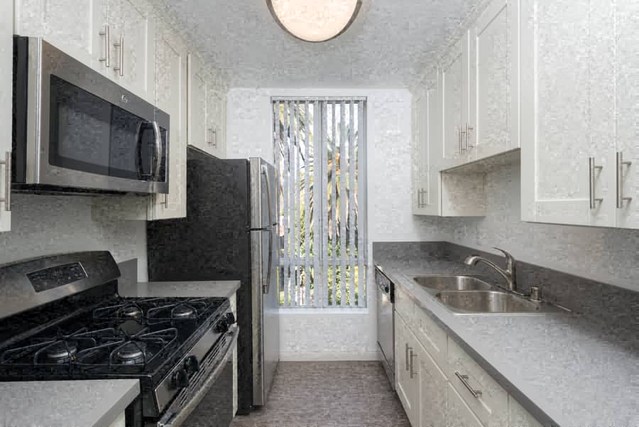 A kitchen with a black stove top oven and a black microwave.