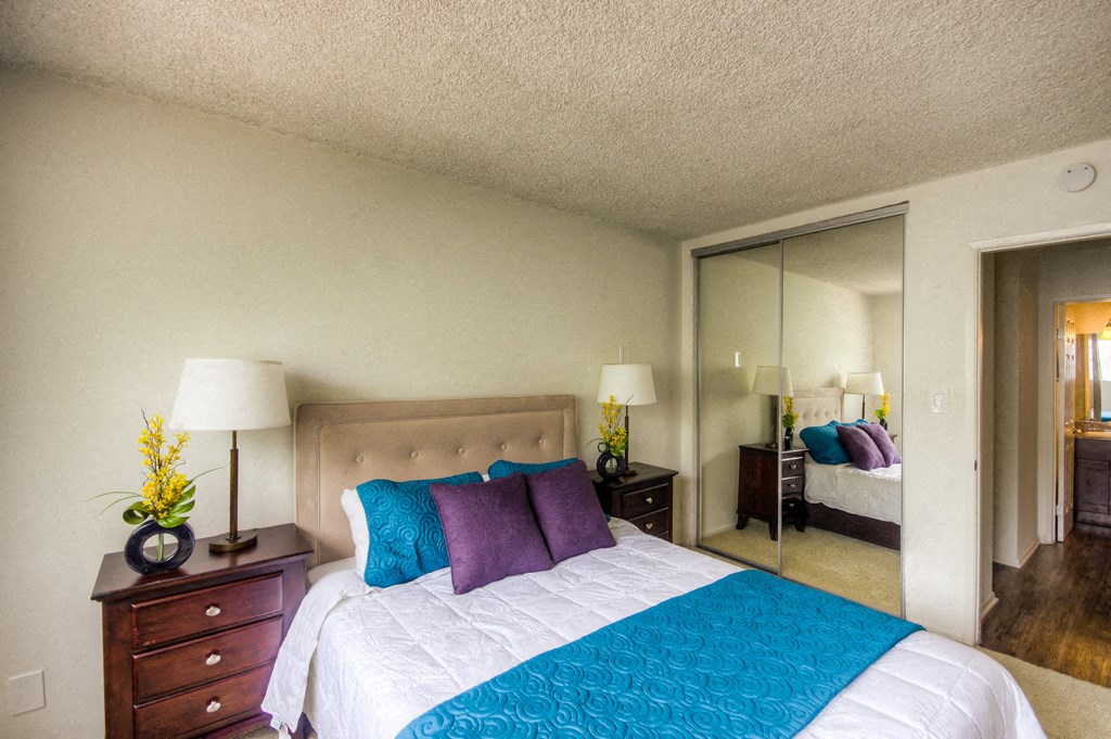 a bedroom with a large bed and a mirror