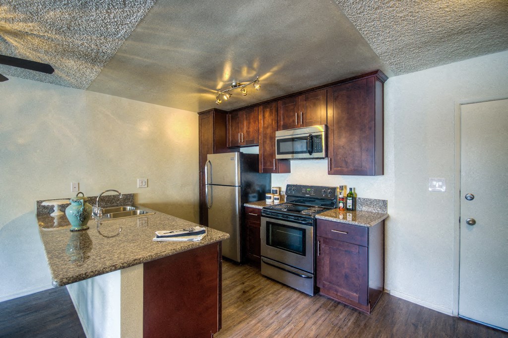 a kitchen with stainless steel appliances and granite counter tops