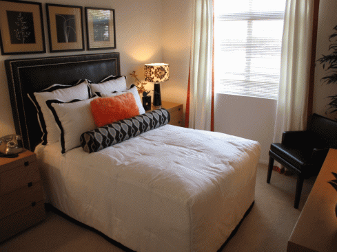 a bedroom with a bed and a lamp and a window