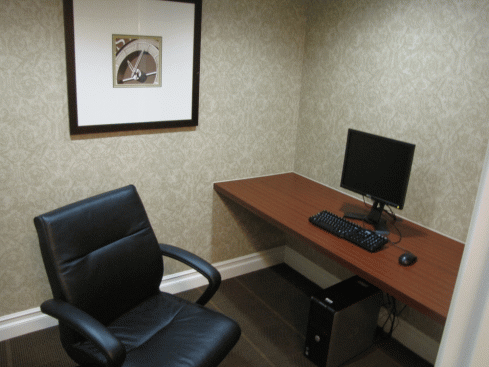 a desk with a computer and a chair in a room