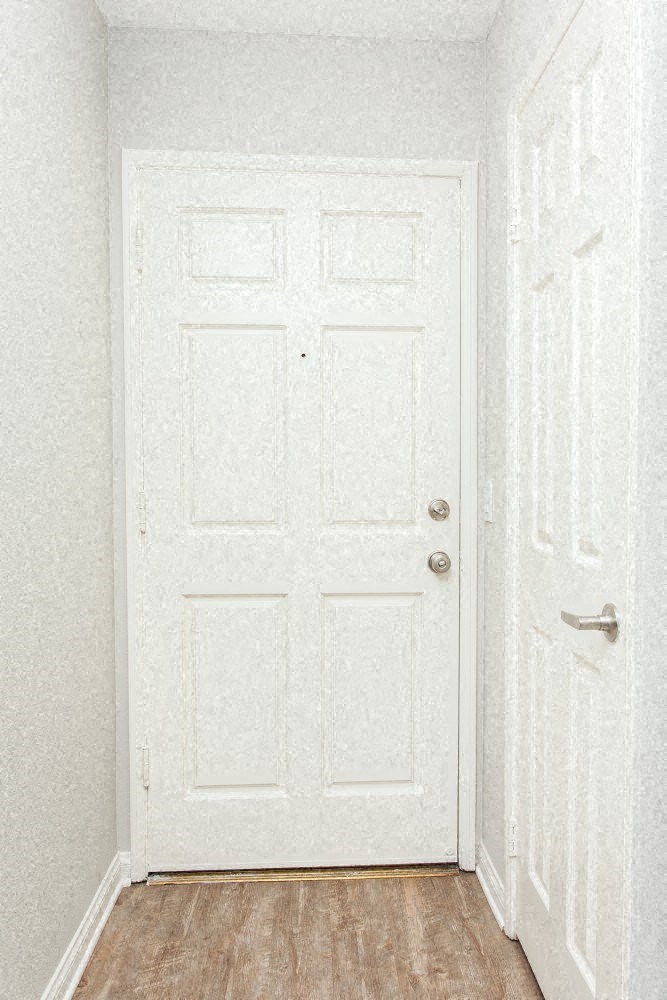a white door in a room with a wooden floor