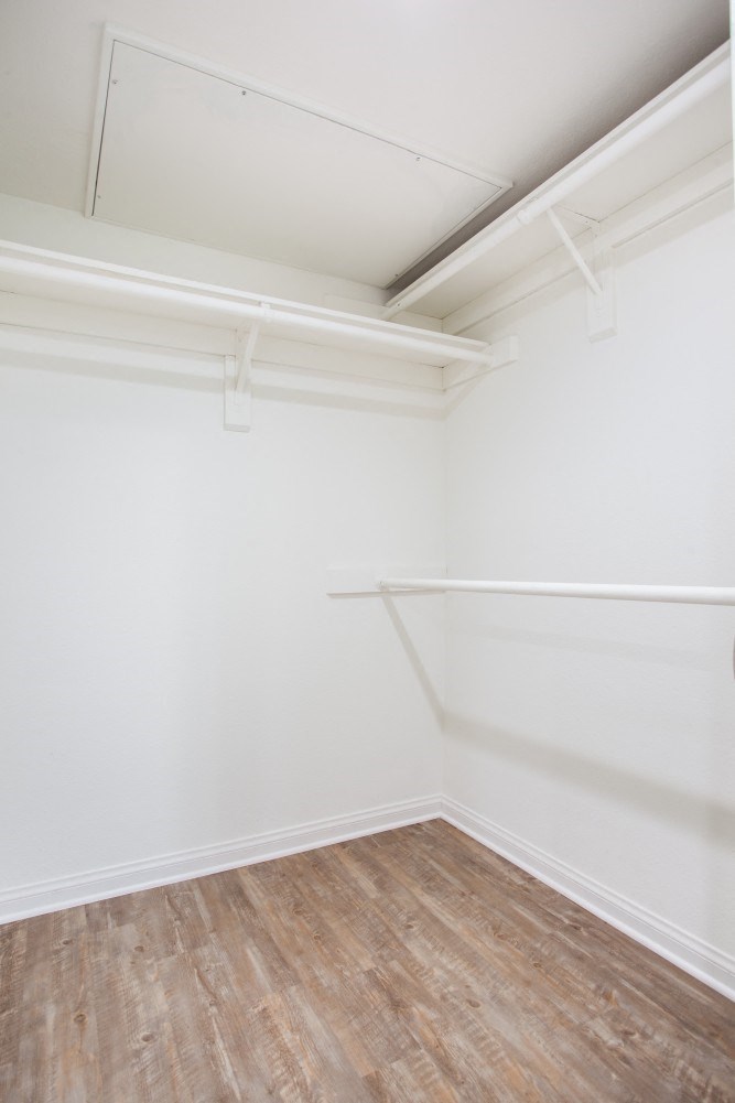 an empty room with white walls and a wood floor