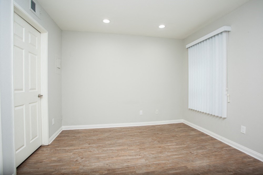 an empty room with a window and a door