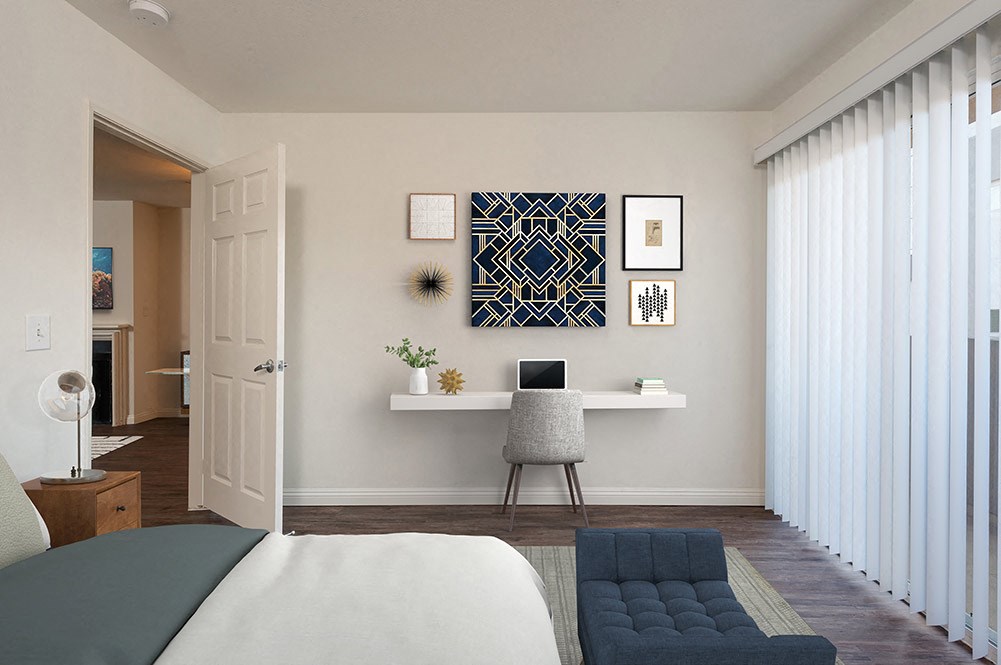 a bedroom with a bed and a desk with a laptop