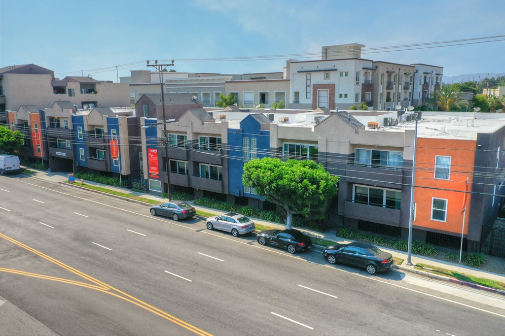 an aerial view of a city street with cars parked in front of buildings