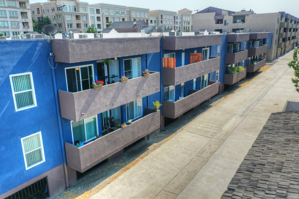 a view of a building from above with balconies and a sidewalk