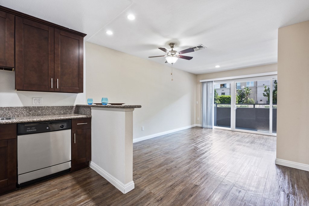 an empty kitchen and living room with a ceiling fan