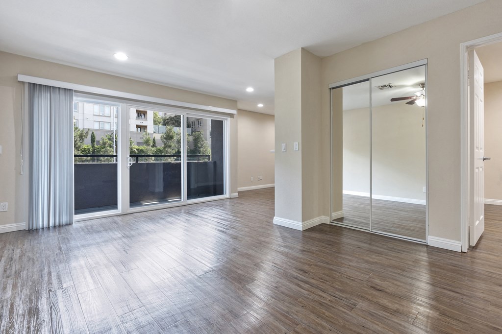 an empty living room with sliding glass doors to a balcony