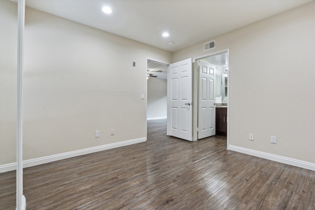 an empty living room with white walls and wood flooring