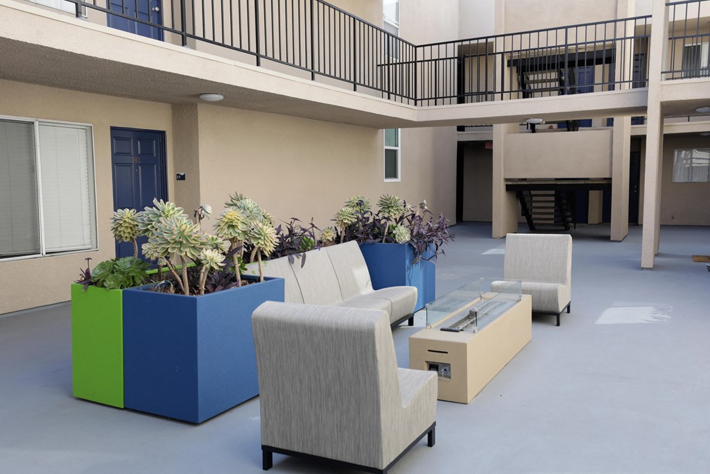 a lobby with chairs and couches and potted plants