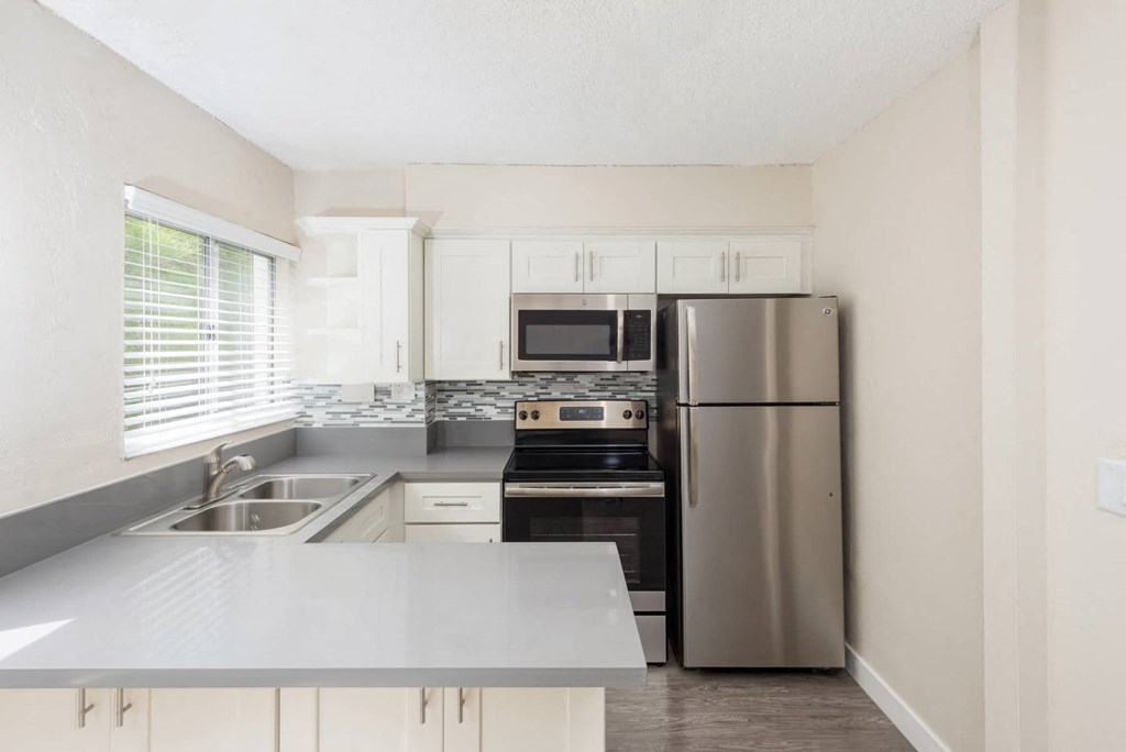 a kitchen with stainless steel appliances and white cabinets
