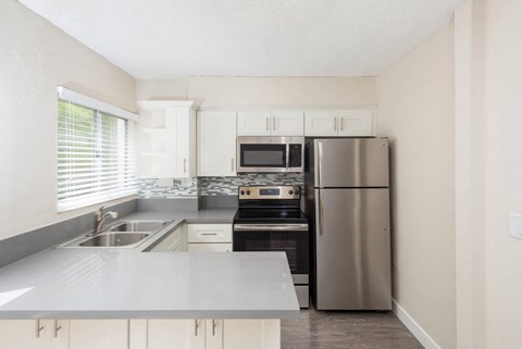 a kitchen with stainless steel appliances and white cabinets