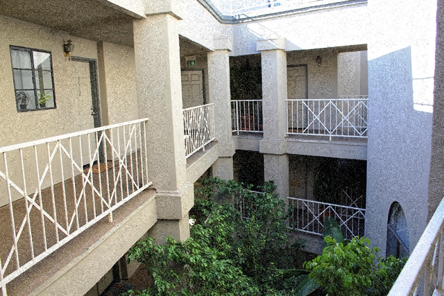 an apartment building with two balconies and trees