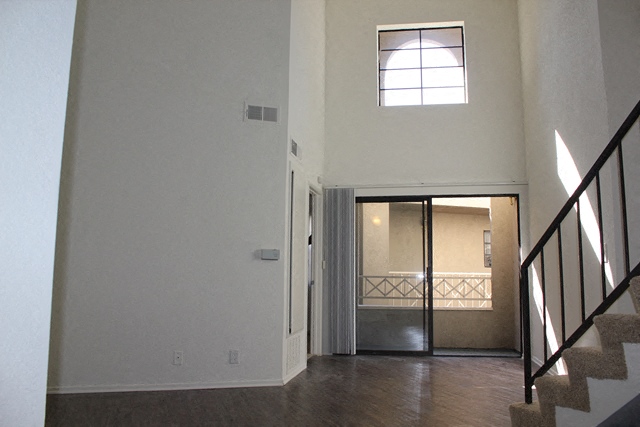 an empty house with a staircase and a door to a bathroom