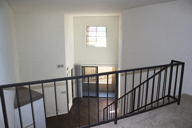 a view from the top of a staircase looking into a room with a window