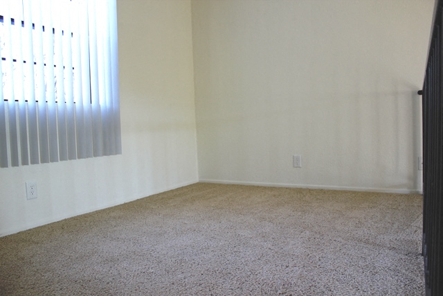 an empty room with white walls and a window