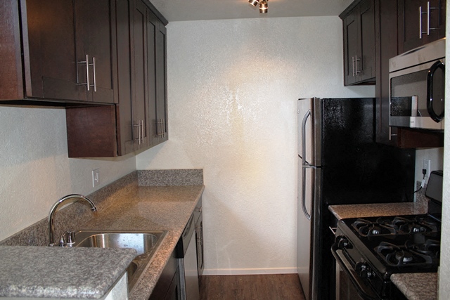 a kitchen with a sink and a stove and a refrigerator