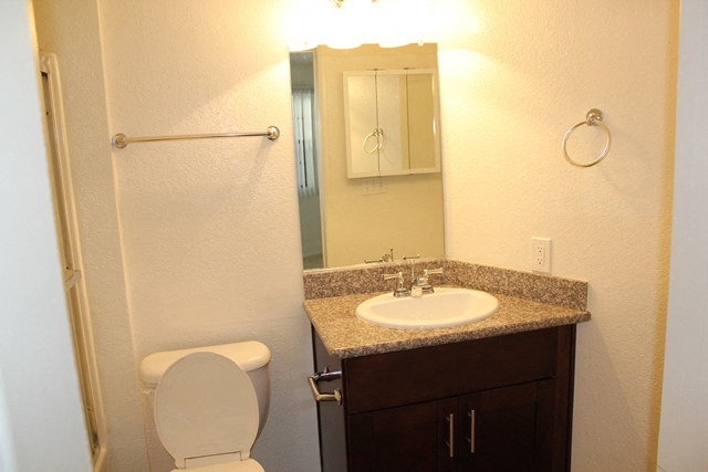 a bathroom with a sink toilet and a mirror