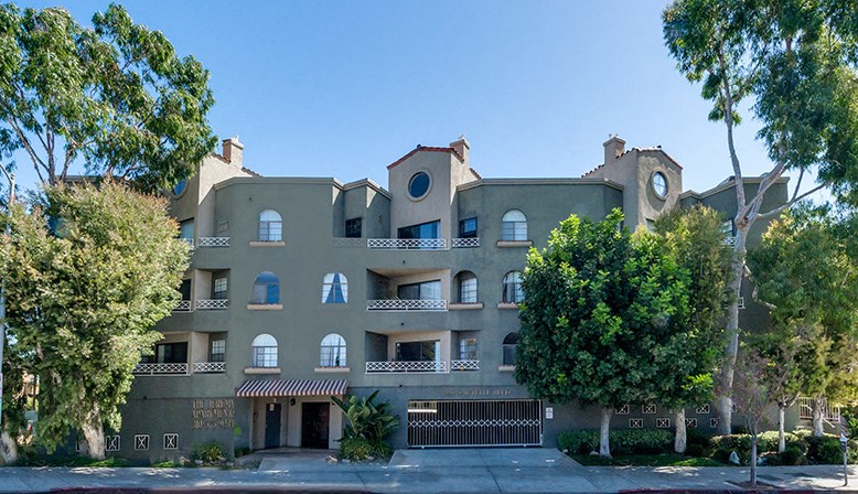 an apartment building with trees in front of it