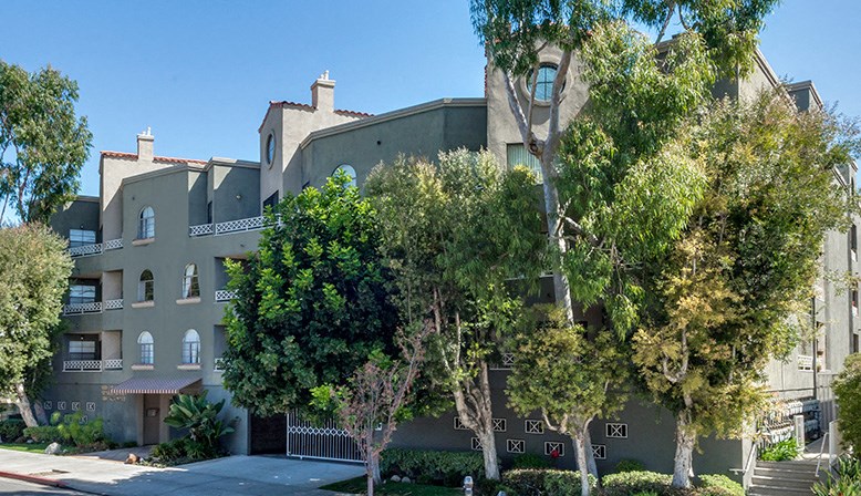 an apartment building with trees in front of it