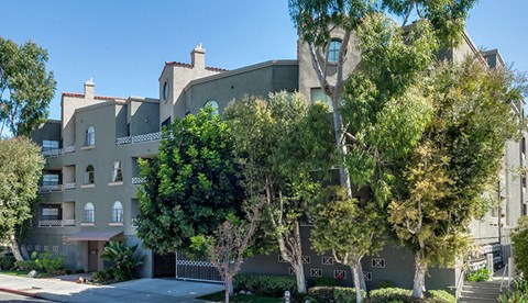 an apartment building with trees in front of it
