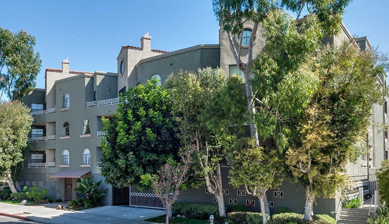 a large apartment building with trees in front of it