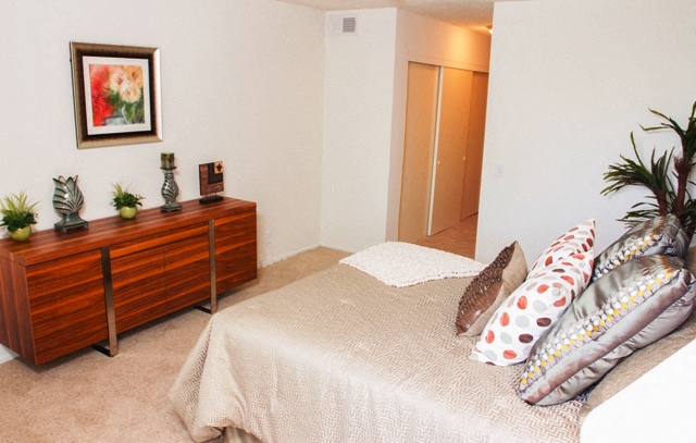 a bedroom with a bed with pillows and a dresser