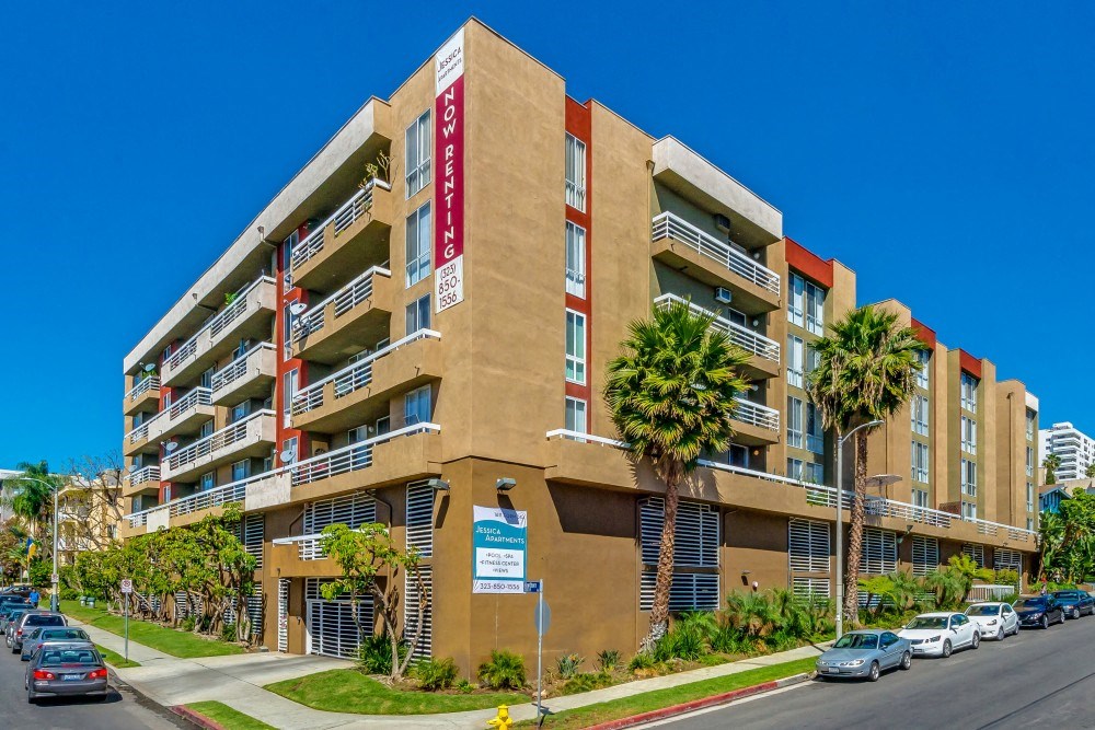 a large apartment building with palm trees in front of it