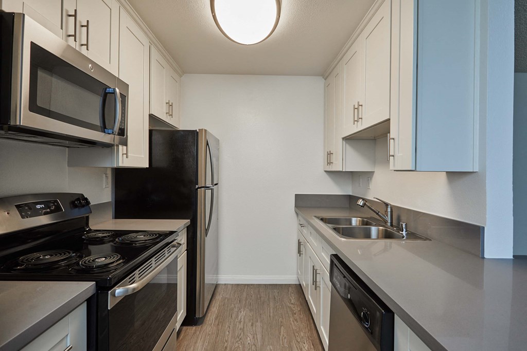 a kitchen with stainless steel appliances and white cabinets