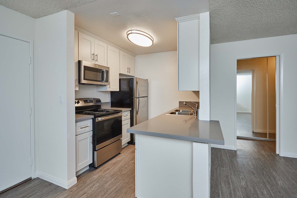 a renovated kitchen with white cabinets and stainless steel appliances