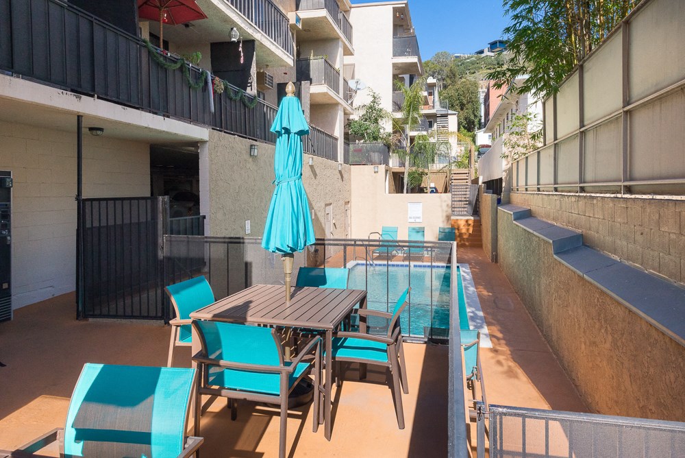 a patio with a pool and a table and chairs