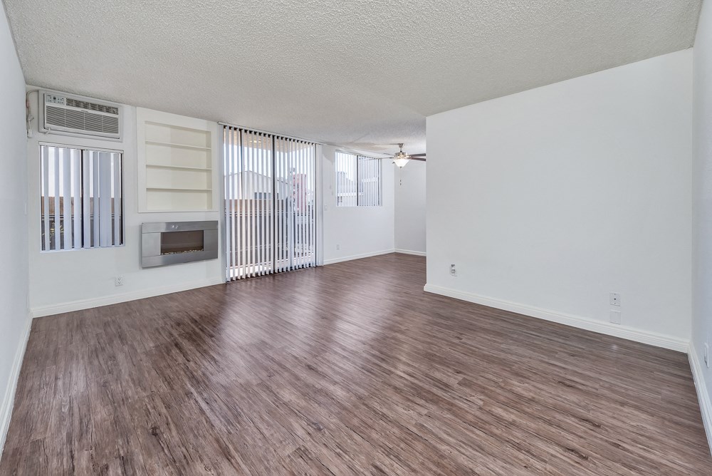 an empty living room with wood flooring and a fireplace