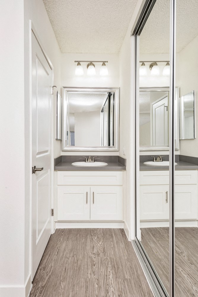 a white bathroom with a mirror and a sink