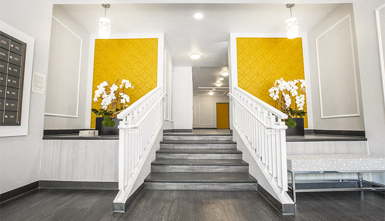 the stairway in the lobby of a building with yellow walls