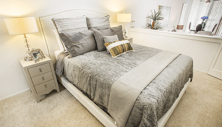 a bedroom with a bed and a night stand