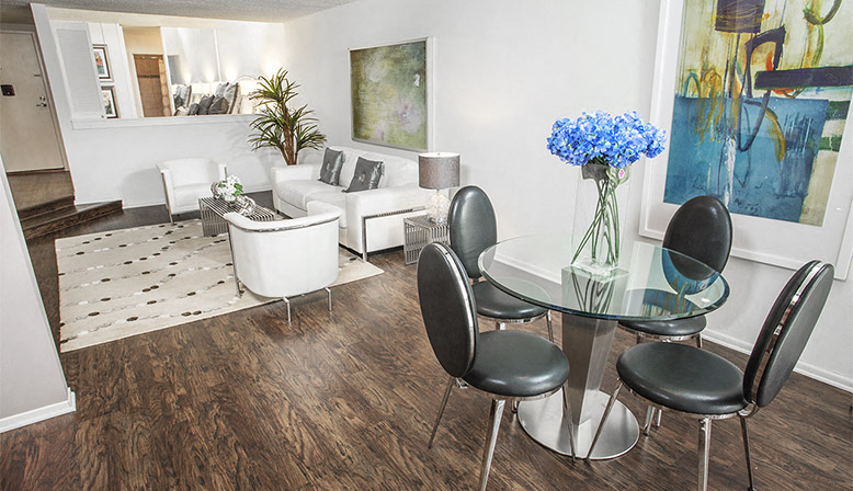 a living room and dining room with a table and chairs