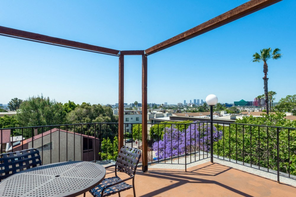 a balcony with a table and chairs and a view of the city