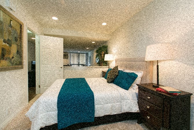 a bedroom with a bed with a blue blanket on it