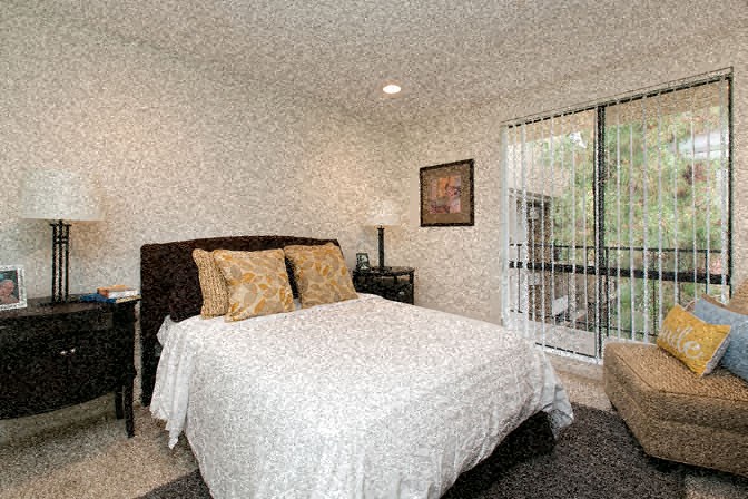 a bedroom with a bed and a large window