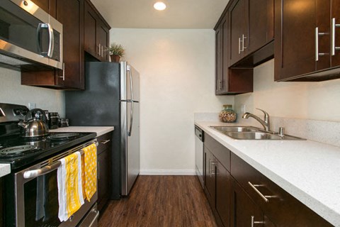 a kitchen with a stove refrigerator and sink