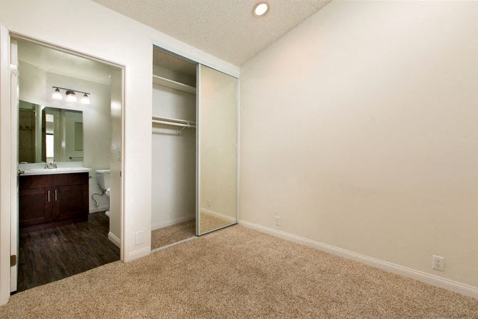 an empty bathroom with a mirror and a closet