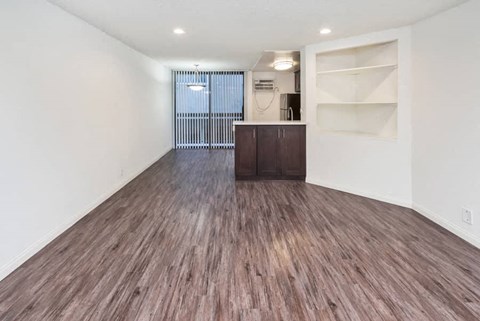 an empty living room with wood flooring and white walls
