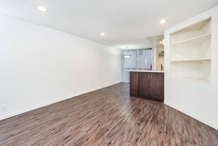 an empty living room with white walls and wood flooring